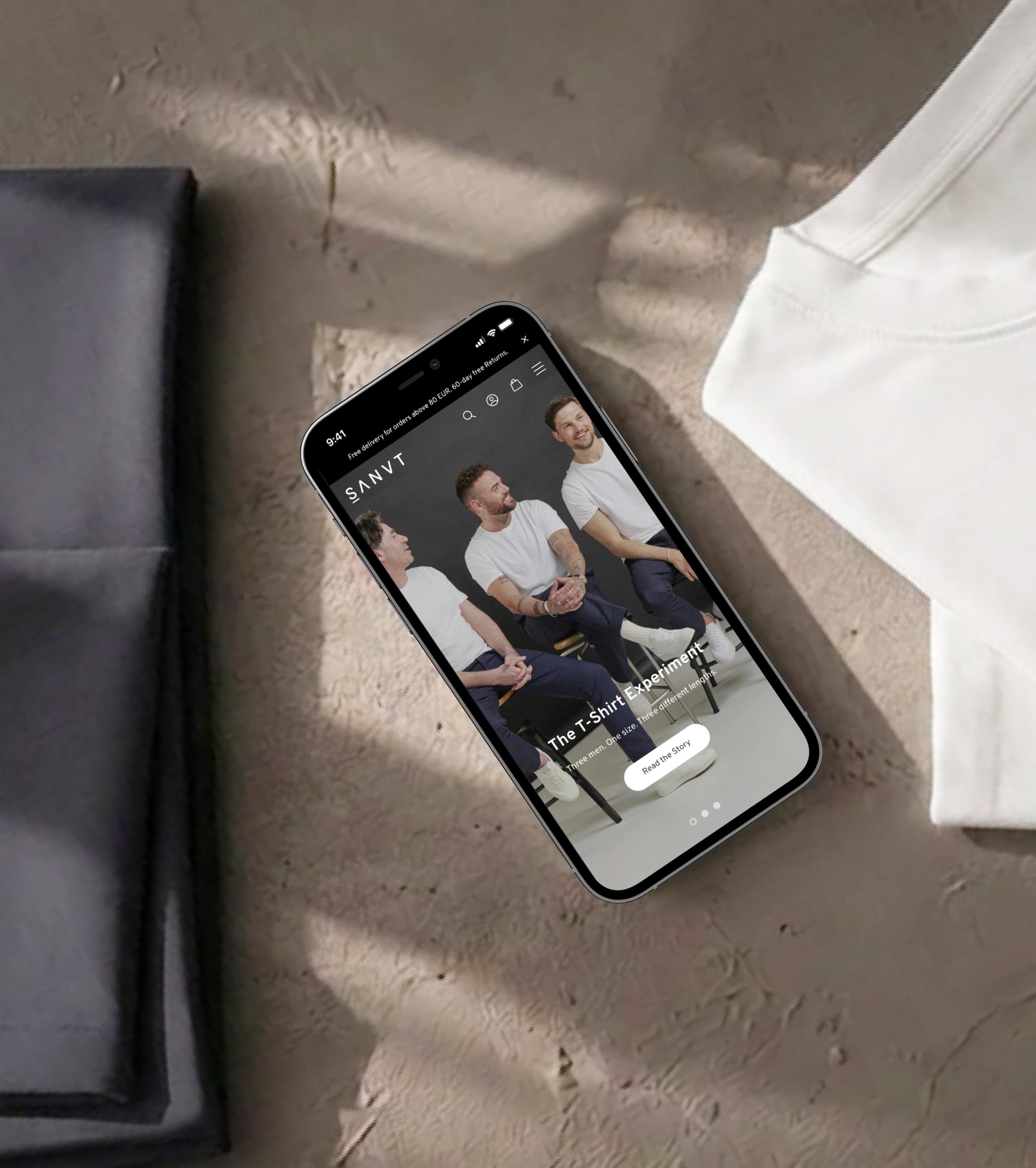 SANVTs Shopify Store auf einem Smartphone neben gefalteten Premium-T-Shirts