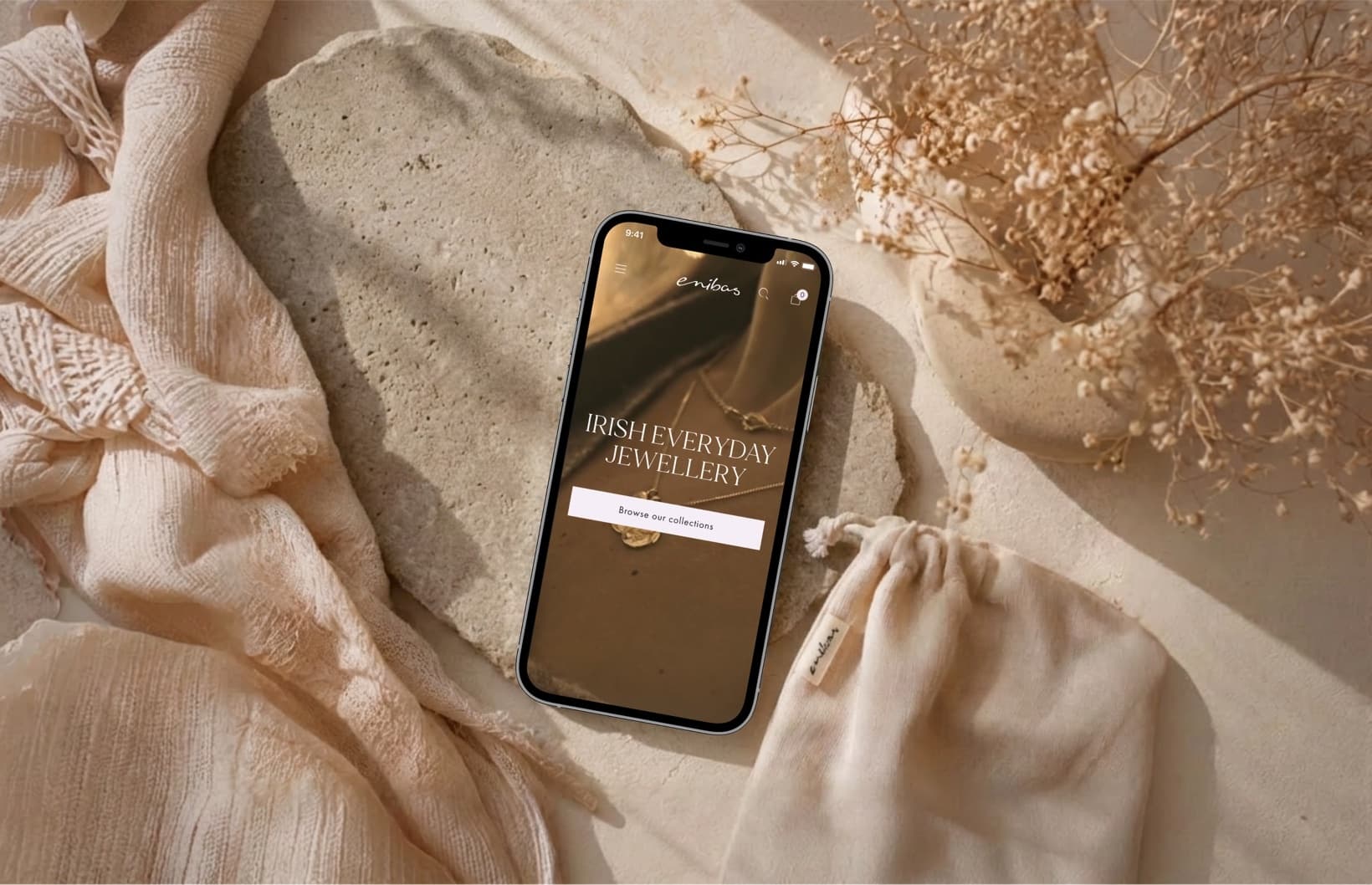 Der Enibas-Schmuck-Storefront auf einem Smartphone zwischen Trockenblumen